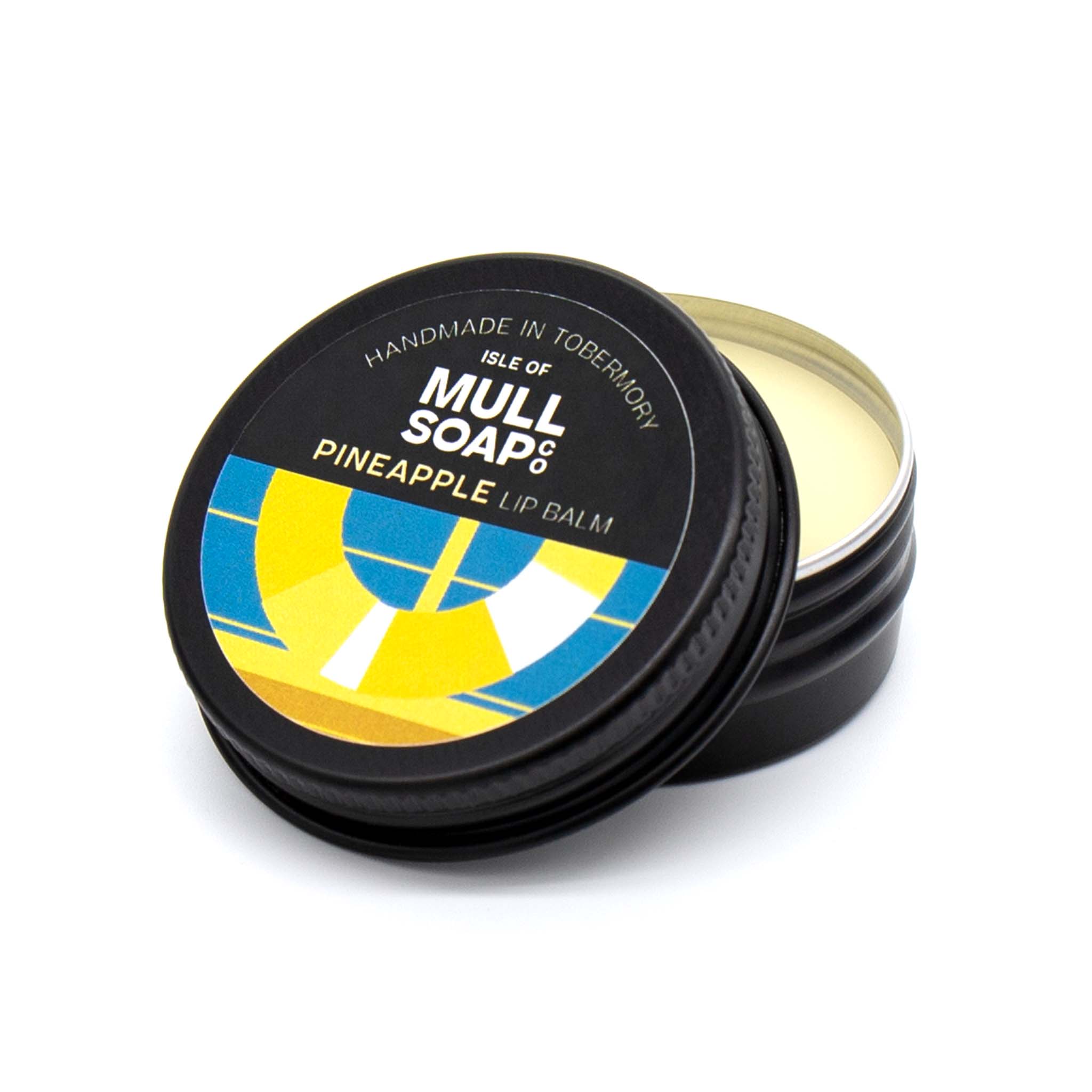 pineapple lip balm in a black tin with colourful label. vegan lip balm handmade in Tobermory by the Isle of Mull soap co.