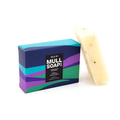 a mull heather soap box sitting next to a soap bar. The box is a purple and green rolling hills design. The soap is described as bright, fresh and light. Handmade in Tobermory by the Isle of Mull soap co.